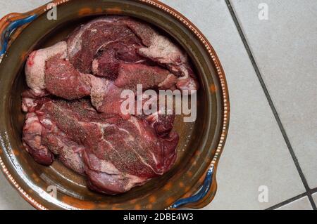 Cooking beef birria stew, Mexican food from Jalisco state. Raw seasoned beef marinating in birria sauce Stock Photo