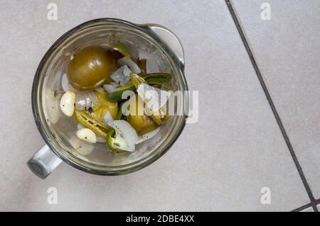 Making Mexican green tomatillo and chili salsa, Mexican food. Ingerdient in blender jar, sauce in blender jar Stock Photo