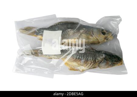 Dried salted crucian fishes in a transparent package with a white label isolated on white background. Snack to beer. Stock Photo