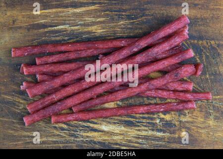 Dry salmon sticks isolated on wooden background. Snack Fish to beer. Close up. Stock Photo
