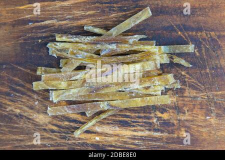 Dried salted tuna meat strips on wooden background. Snack Fish to beer. Close up. Stock Photo