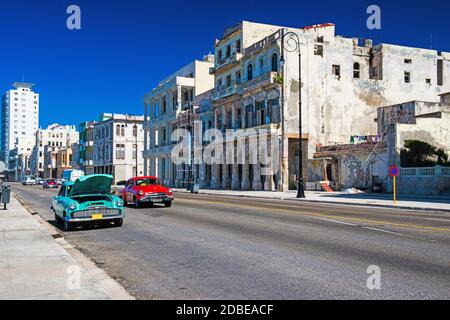 Colorful vintage cars at Malecon in Havana, Cuba, colonial houses next to the street Stock Photo