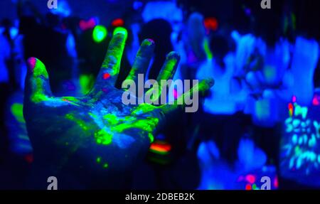 Hands covered in fluorescent paint Stock Photo