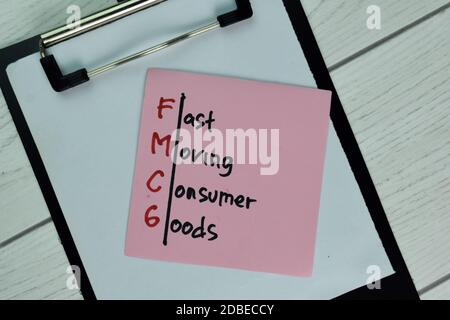 FMCG - Fast Moving Consumer Goods write on sticky note isolated on Wooden Table. Stock Photo