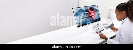 Dentist Doctor Using Computer Technology For Teeth X Ray Stock Photo
