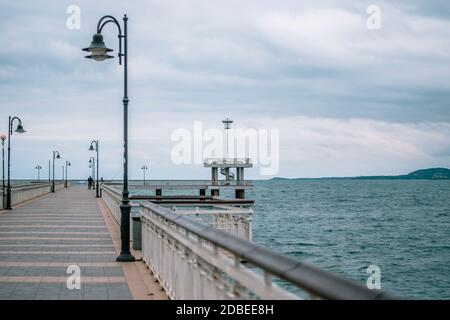 Sea bridge in Burgas, Bulgaria in winter autumn season. Grey white sky, gloomy day. Stock Photo