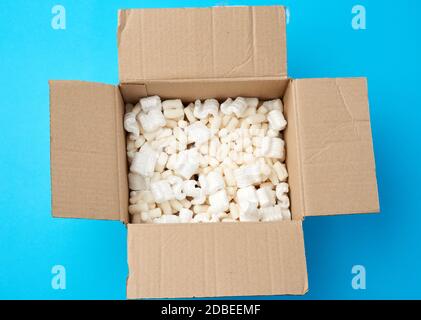 open brown cardboard box with white foam filling for transporting goods, top view Stock Photo