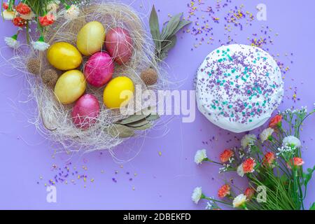 pattern of Easter eggs in the nest and Easter cake on a purple background Stock Photo
