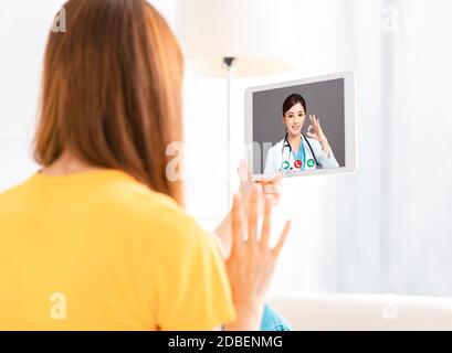 young woman  Video chatting With Doctor On digital tablet Stock Photo