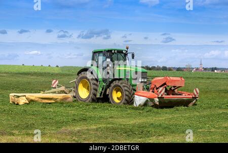 Tractor mowing grass on a field Stock Photo