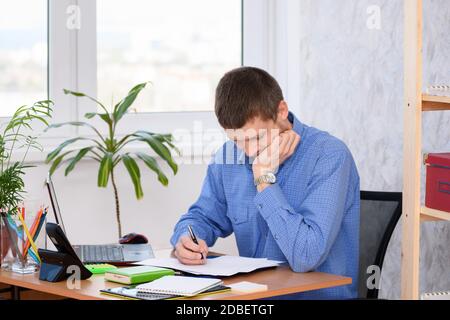Pensive employee reads business papers in the office Stock Photo