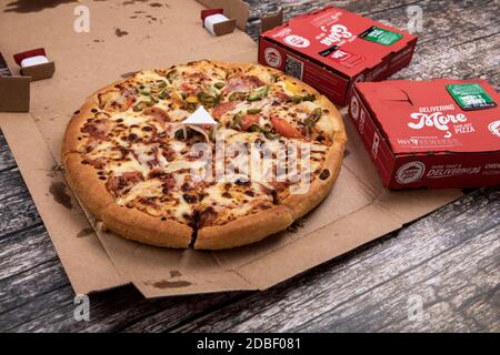 Still life photograph of pizza in Pizza Hut box with side dishes