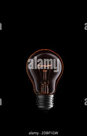 Burning Light bulb on black background. Stock Photo