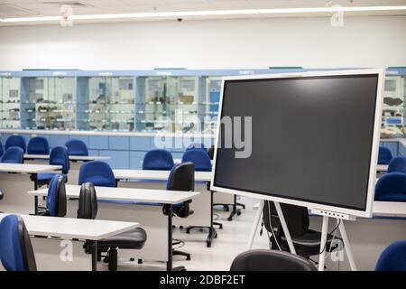 Empty Contemporary multimedia Classroom or conference hall with digital blackboard, chair and desk & screen light Stock Photo