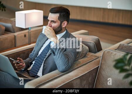 Business official drinking some coffee in a waiting hall Stock Photo