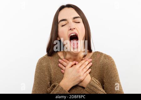 Beautiful woman yawns of boredom on white background Stock Photo