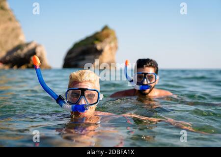 Happy friends men enjoying summer vacation and scuba diving