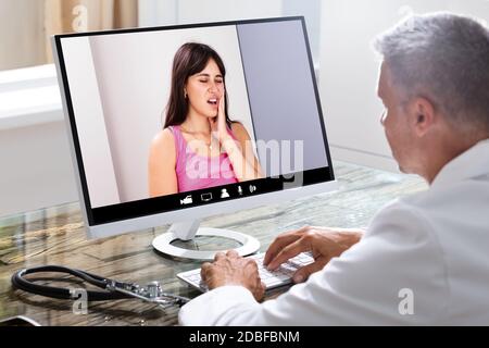 Doctor In Video Conference Call With Sick Patient Stock Photo