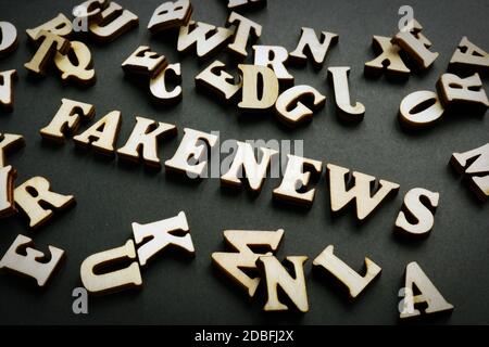 Fake news concept. Letters on the black desk. Stock Photo