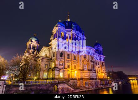 Berliner Dom cathedral church, a landmark monument, is lit in colors at night during the Festival of Lights, viewed from across the Spree river in Ber Stock Photo