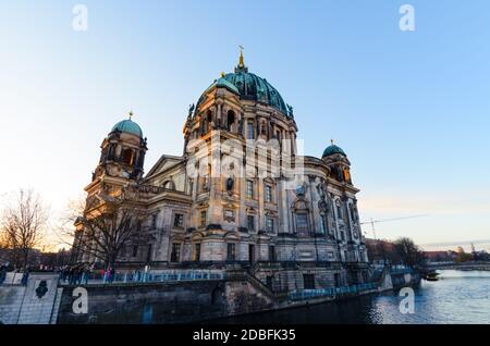Berliner Dom cathedral church, a landmark monument,, lit by sunshine at sunrise, is viewed from across the Spree river in Berlin, Germany Stock Photo