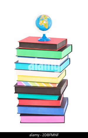 A globe on top of stack of colorful books with different sprayed edges, isolated on white background. Education and travel concept. Stock Photo