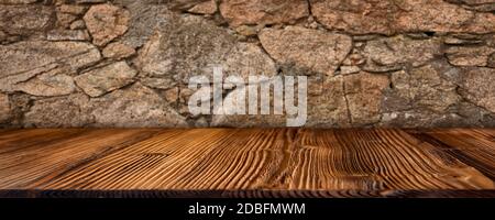 Old stone wall with empty rustic wooden table in a basement. Horizontal background with short depth of field for a decoration. Space for concept, desi Stock Photo