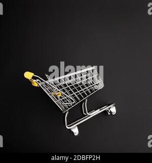Mini shopping cart on black background Stock Photo