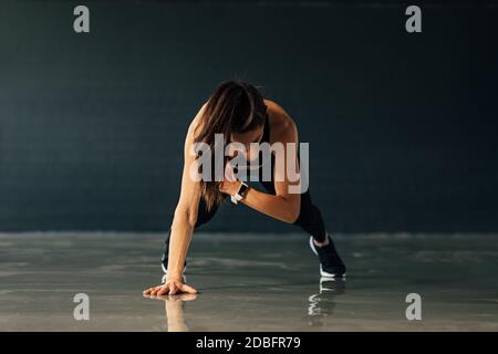 Young muscular woman doing push ups exercises in gym Stock Photo