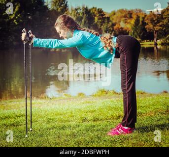 Vintage retro effect filtered hipster style image of nordic walking adventure and exercising concept - woman doing exercise with nordic walking poles Stock Photo