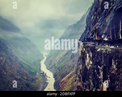 Vintage retro effect filtered hipster style image of car on dangerous road in Himalayas mountains in gorge above precipice Stock Photo