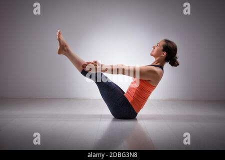Beautiful sporty fit yogini woman practices yoga asana Paripurna navasana - boat pose Stock Photo