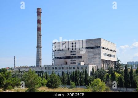 An old Soviet factory with a pipe. Abandoned Soviet industry. Stock Photo