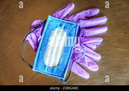 Top view of N-95 mask and nitrile disposable gloves on a steel surface