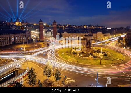 View Placa d'Espanya, Plaza de Espana, the Spanish Square in Barcelona, Catalonia, Spain with city traffic in the evening blue hour with light trails Stock Photo