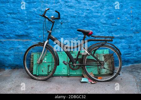 Old bicycle at the wall of blue house in streets of of Jodhpur, also known as Blue City due to the vivid blue-painted Brahmin houses, Jodhpur, Rajasth