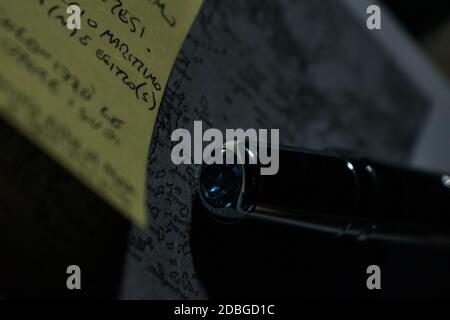 Shot of pen on books with greek and Italian words and a post-it note Stock Photo