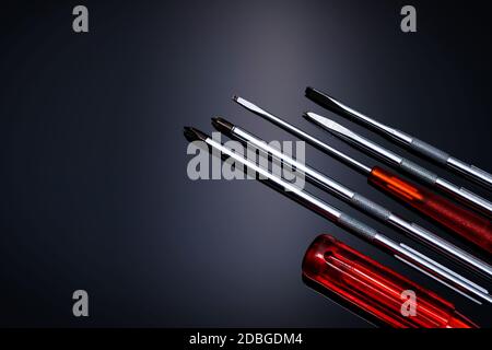 Screwdriver and center punch. Mechanic hand tools. Screwdriver sets with interchangeable blades. Mobile tools set. Tools set on black background. Scre Stock Photo