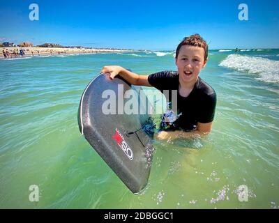 Young bodyboarder enjoying the surf at East Wittering beach in the UK Stock Photo