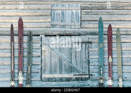 Vintage wooden weathered ski's in front of an old barn with snowfall Stock Photo