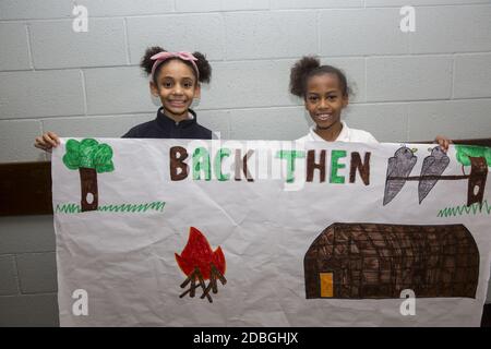 Students show a history project they worked on showing symbolistic pictures of how people lived in the past. Stock Photo