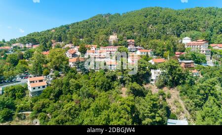 Aerial view of Pano Platres village,winter resort, on Troodos mountains, Limassol, Cyprus. Bird's eye view of pine tree forest, red roof tiled houses, Stock Photo