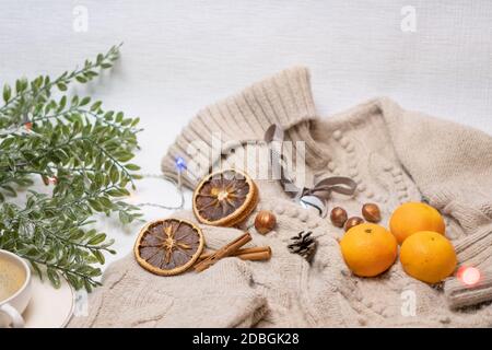 Medical mask and accessories for the New Year, a green twig, dry oranges, tangerines, a woolen sweater. Flatley on a white background. High quality photo Stock Photo
