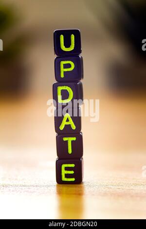 Update, vertical text in black cubes on a wooden table Stock Photo