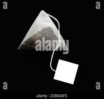 Pyramid shape teabag isolated on the dark background Stock Photo