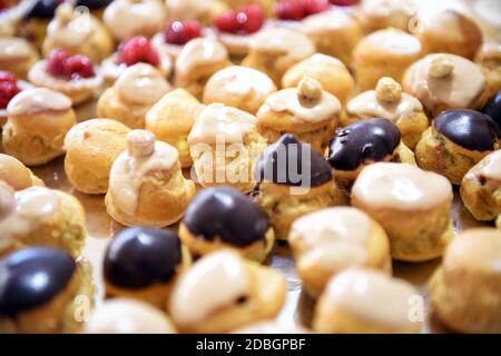 Close up on assorted puff pastries on a buffet table arranged in neat rows at a catered event in a full frame view Stock Photo