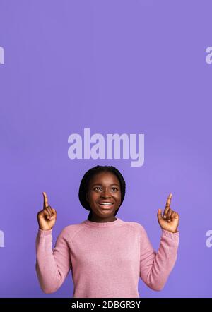 Look There. Cheerful Black Young Woman Pointing Up At Copy Space Stock Photo