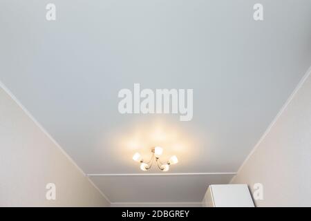 Classic white matte stretch ceiling in the interior of the room Stock Photo
