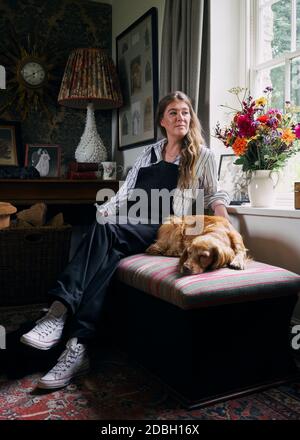 Interior designer Flora Soames and her dog Humbug, photographed at her Wiltshire home. Flora wears Carrier Company dungarees, With Nothing Underneath Stock Photo