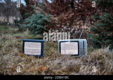 White noise on two analogue TV sets in outdoor environment Stock Photo